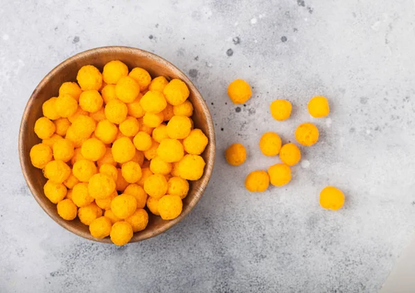Aufgeblasene goldene Käsebällchen als klassische Kinderjause auf hellem Hintergrund. — Stockfoto