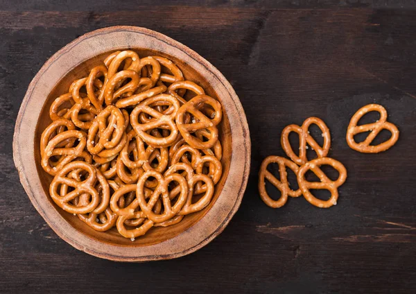 Hard salted pretzels classic snack for beer in wooden bowl on wooden background. — Stock Photo, Image