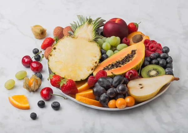 Baies d'été fraîches crues biologiques et fruits exotiques en plat blanc — Photo