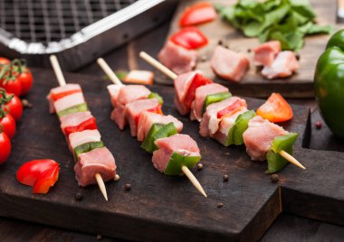 Çatal ve bıçak ile ahşap arka planda taze sebzeler ile doğrama tahtasında Paprika ile ham domuz kebap. Tuz ve biber ile marul ve Paprika ve kiraz domates. Metin alanı