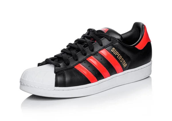 London, UK - 05. Juni 2019: adidas Originals Superstar Schwarzer Schuh mit roten Streifen auf weißem Hintergrund.. — Stockfoto