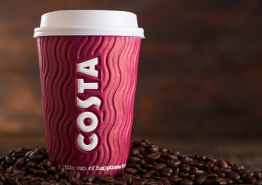 Londra, İngiltere - 05 Haziran 2019: Costa Coffee Paper Cup ahşap arka planda kahve çekirdekleri ile götürmek için