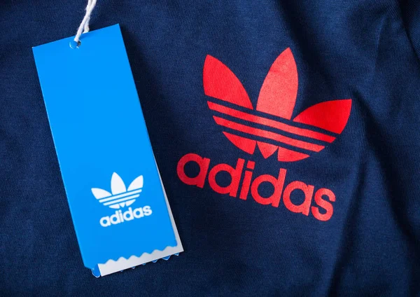 Лондон, Великобританія-05 червня 2019: оригінальні документи Adidas, етикетка червоного кольору на синю тканину з торговим тегом. Німецька мультинаціональна корпорація. — стокове фото