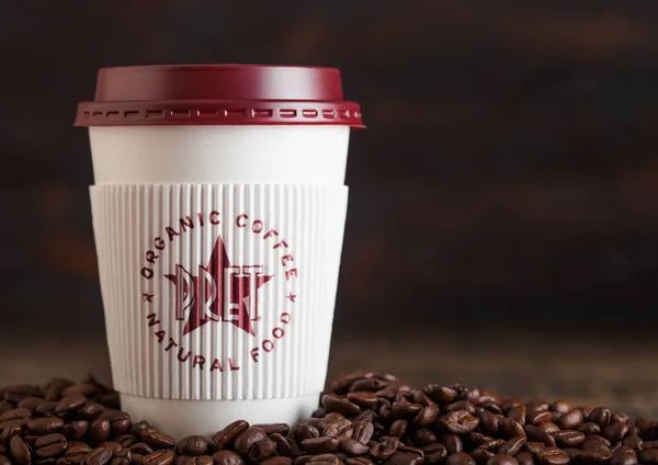 Λονδίνο, UK-05 Ιουνίου, 2019: PRET A φάτνη Κύπελλο καφέ για να πάρει μακριά με κόκκους καφέ σε ξύλινο φόντο. — Φωτογραφία Αρχείου