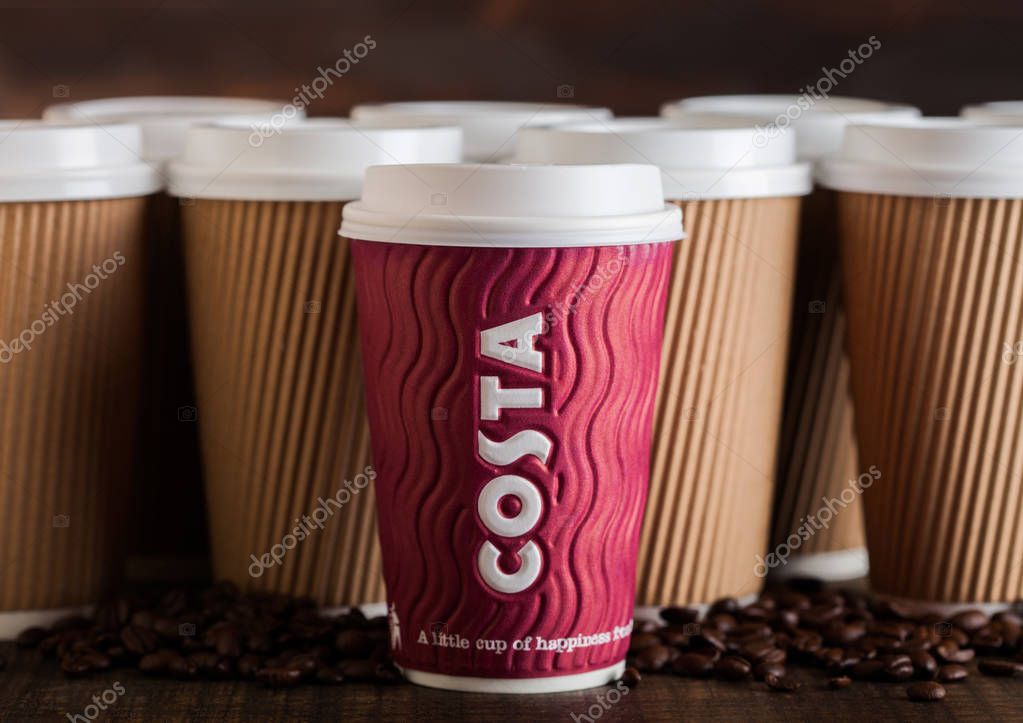 LONDON, UK - JUNE 05, 2019: Costa Paper Cup for take away with coffee beans on wooden background with blank coffee cups.