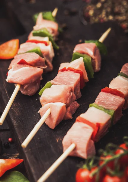 Ahşap arka planda tuz ve biber ile doğrama tahtasında Paprika ile Çiğ domuz eti ve tavuk kebap.