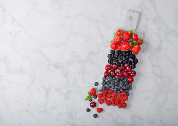Φρέσκα βιολογικά φρούτα του καλοκαιριού αναμειγνύονται σε λευκό μάρμαρο σε μαρμάρινη φόντο. Σμέουρα, φράουλες, βατόμουρα, βατόμουρα και κεράσια. — Φωτογραφία Αρχείου
