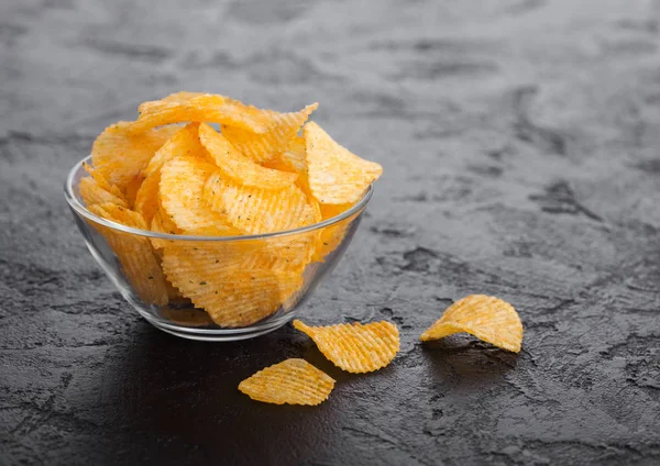 Placa de tigela de vidro com batatas fritas batatas fritas com páprica sobre fundo mesa de pedra preta . — Fotografia de Stock