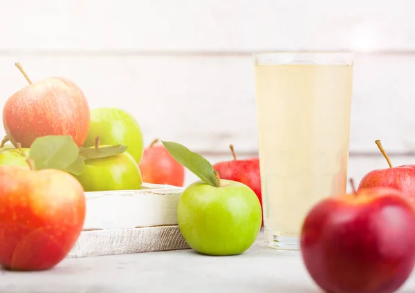 Bicchiere di succo di mela biologico fresco con braeburn rosa signora mele in scatola su sfondo di legno con luce del sole — Foto Stock