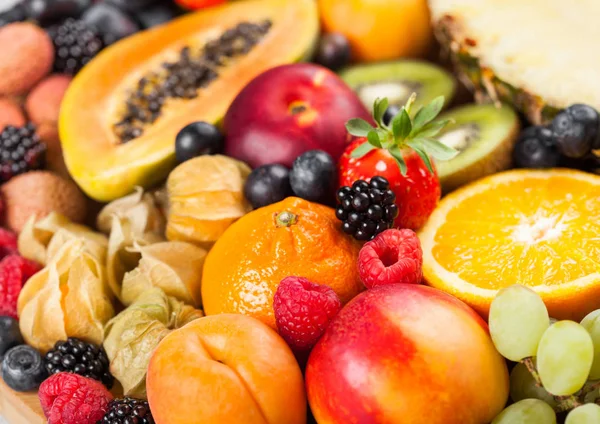 新鲜的生有机夏季浆果和异国情调的水果。宏观。闭上你的嘴菠萝、木瓜、葡萄、油桃、橘子、杏子、猕猴桃、荔枝、樱桃和植物、覆盆子. — 图库照片