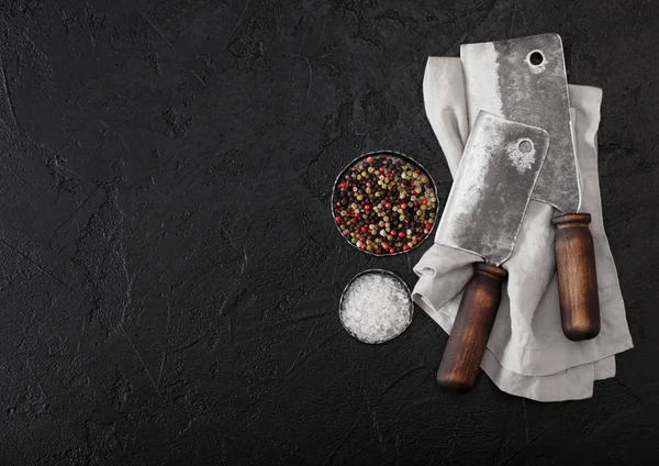 Hatchets de faca de carne vintage na toalha de cozinha e fundo de mesa de pedra preta. Utensílios de talho. Sal e pimenta — Fotografia de Stock