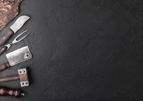 Vintage maso nůž a vidličku a sekery s vintage prkýnko a černý stůl pozadím. Řezník nádobí. Prostor pro text — Stock fotografie