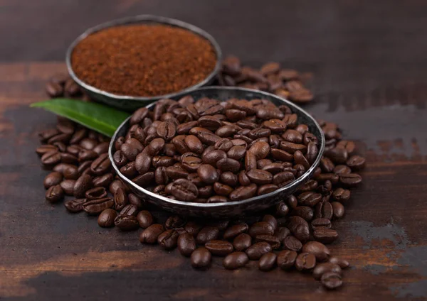 Verse rauwe biologische koffiebonen met gemalen poeder en koffie boom blad op houten achtergrond. — Stockfoto