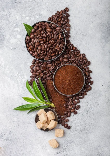 Verse rauwe biologische koffiebonen met gemalen poeder en rietsuiker blokjes met koffie TREA blad op lichte keuken tafel achtergrond. — Stockfoto