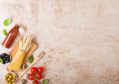 Ahşap arka plan üzerinde domates sosu şişesi ile bıldırcın yumurtası ile ev yapımı spagetti makarna. Klasik İtalyan köy yemekleri. Sarımsak, champignons, siyah ve yeşil zeytin. Metin için alan