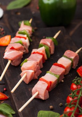 Ahşap arka planda tuz ve biber ile doğrama tahtasında Paprika ile Çiğ domuz eti ve tavuk kebap.