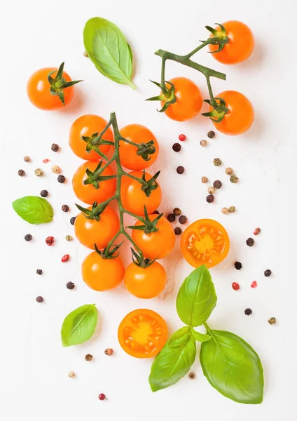 Cereja orgânica laranja arrebatamento tomates na videira com manjericão e pimenta no fundo da cozinha branca — Fotografia de Stock