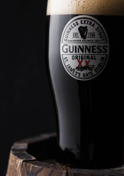 Лондон, Великобританія-27 квітня 2018: оригінальне скло Гіннеса оригінальне Стаут пива поверх старої дерев'яної бочки. — стокове фото