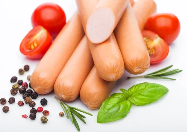 Klassische gekochte Schweinswürste mit Paprika und Basilikum und Kirschtomaten auf weißem Hintergrund. Makro — Stockfoto