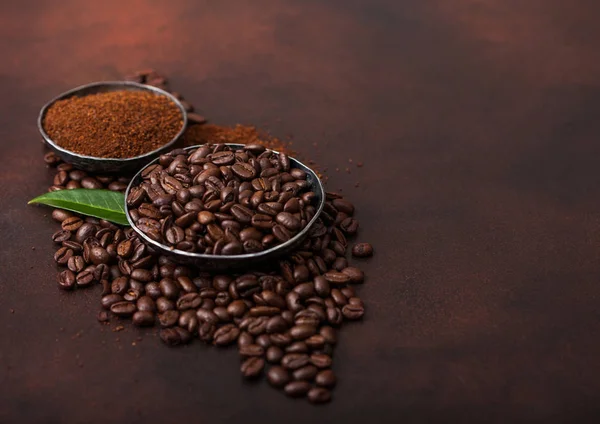 Świeże Surowe organiczne ziarna kawy z zmielony proszek i liść kawy TREA na brązowym tle. — Zdjęcie stockowe