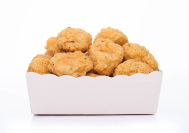 Beyaz arka plandaki fast food yemekleri için çocuk kağıt bardağında çıtır çıtır tavuk patlağı ısırıkları..