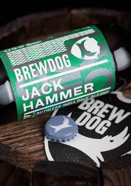 LONDON, UK - AUGUST 10, 2018: Brewdog Jack Hammer beer coaster with bottle top and bottle on wooden barrel. — Stock Photo, Image