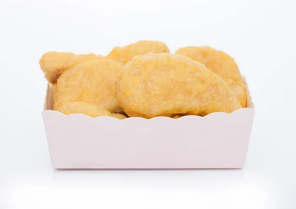 Βουτυρωμένα ψήγματα κοτόπουλου σε παιδικό χάρτινο τετράγωνο κύπελλο για fast food γεύματα σε λευκό φόντο. — Φωτογραφία Αρχείου