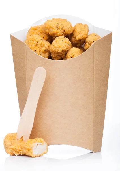 Τραγανό κοτόπουλο ποπ κορν δαγκώματα σε χάρτινο δοχείο για fast food γεύματα σε λευκό φόντο. — Φωτογραφία Αρχείου