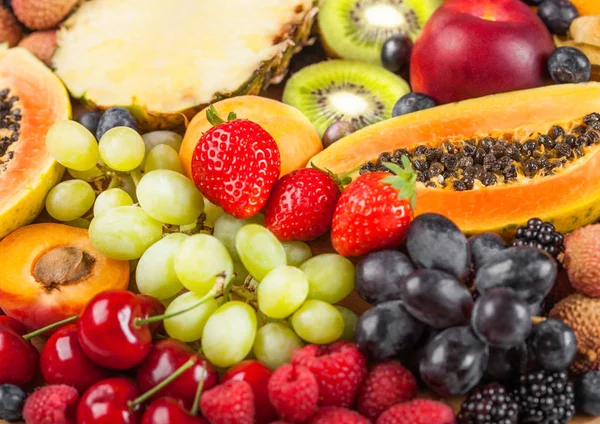 Fresh raw organic summer berries and exotic fruits. Macro. Close up. Pineapple, papaya, grapes, nectarine, orange, apricot, kiwi,  lychees, cherry and physalis, raspberry. — Stock Photo, Image