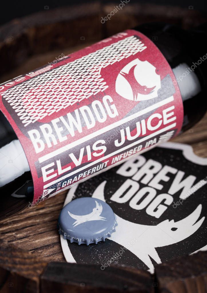 LONDON, UK - AUGUST 10, 2018: Brewdog Elvis Juice beer coaster with bottle top and bottle on wood barrel.