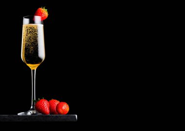 Zarif bardak çilek en iyi ve taze meyveler siyah arka plan üzerine siyah mermer gemide tarih ile sarı şampanya. Metin için yer