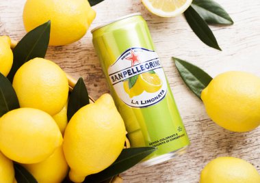 Londra, İngiltere - 27 Nisan 2018: Alüminyum San Pellegrino köpüklü limon soda içecek bambu sepet içinde taze limon ile ahşap arka plan üzerinde olabilir. İtalya üzerinden alınan ve Nestle tarafından dağıtılmış.