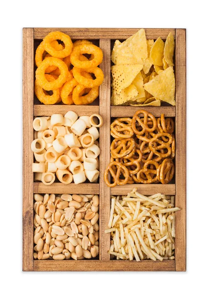 Diversos snacks en caja de madera vintage aislados sobre fondo blanco. Anillos de cebolla, nachos, cacahuetes salados con palitos de patata y pretzels. Adecuado para cerveza y bebidas gaseosas. Vista superior — Foto de Stock