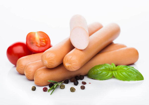 Классические колбасы из свинины с перцем и базиликом и помидорами черри на белом фоне
. 