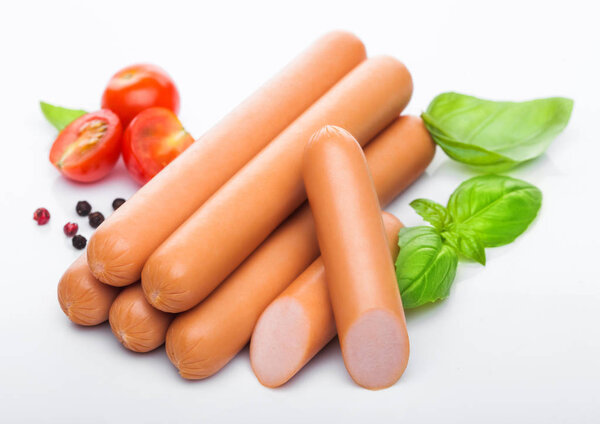 Классические колбасы из свинины с перцем и базиликом и помидорами черри на белом фоне
. 