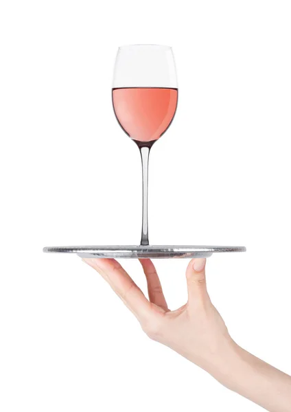 Hand hält Tablett mit rosa Roséweinglas auf weiß — Stockfoto