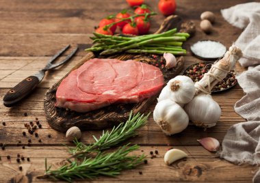 Çiğ biftek, kuşkonmaz, biberiye, domatesli sarımsak, biberli ve biberli biftek. Barbekü için mükemmel et.