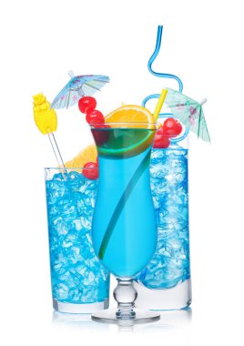 Mavi lagün kokteyl bardakları saman ve turuncu dilimlerle beyaz arka planda tatlı kiraz ve şemsiye..