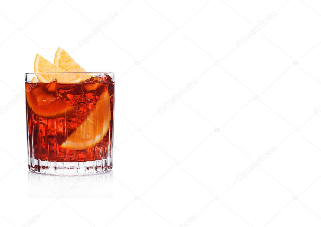 Negroni Cocktail in crystal glass with ice cubes and orange slices on white background. Space for text