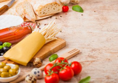 Bıldırcın yumurtalı, domates soslu ve ahşap kaplamalı ev yapımı makarna. Klasik İtalyan köy yemekleri işte. Sarımsak, şampiyon, siyah ve yeşil zeytin, ekmek ve spatula..