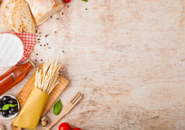 Bıldırcın yumurtalı, domates soslu ve ahşap kaplamalı ev yapımı makarna. Klasik İtalyan köy yemekleri işte. Sarımsak, şampiyon, siyah ve yeşil zeytin, ekmek ve spatula..