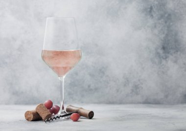 Üzümlü, mantarlı ve arka planda tirbuşonlu pembe gül şarabı..