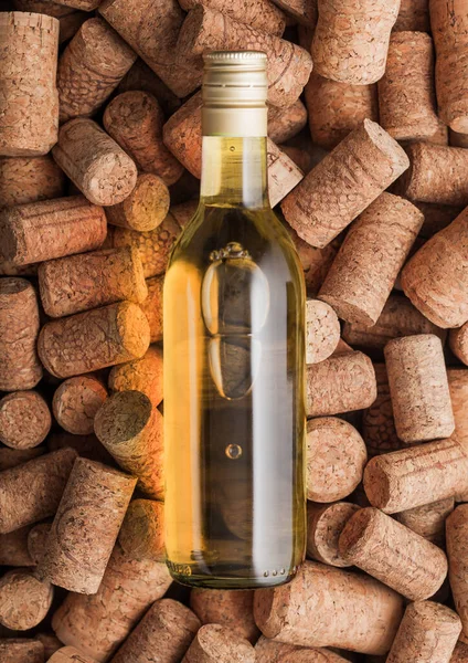 様々なワインコルクの背景の上に白ワインのボトル マクロ — ストック写真