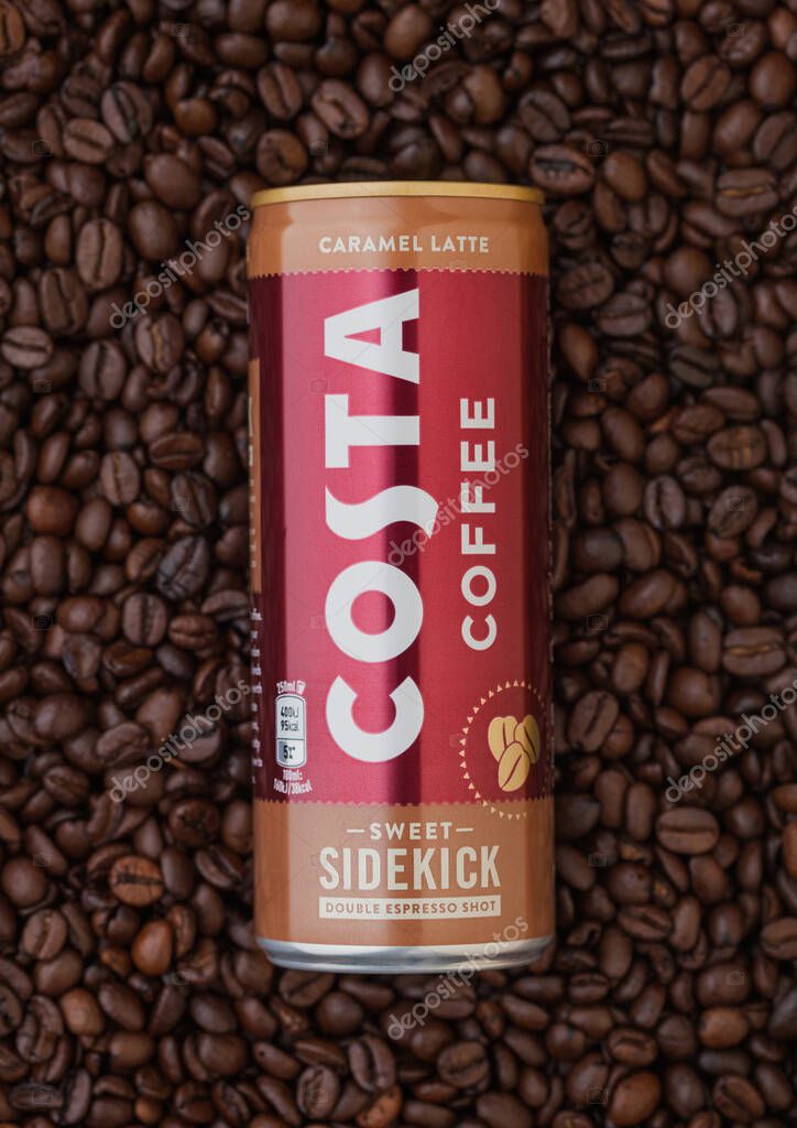 LONDON, UK - SEPTEMBER 09, 2020: Aluminium can of Costa Coffee caramel latte on top of fresh raw coffee beans.