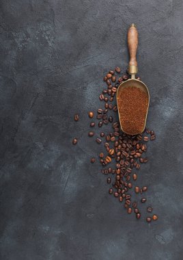 Taze çiğ organik kahve tozu ve siyah arka planda çelik kepçeli fasulye. Metin için boşluk