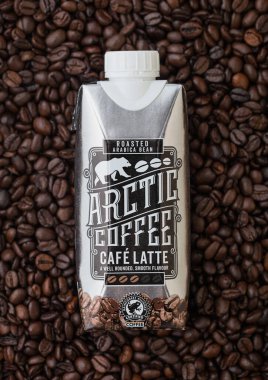 LONDON, İngiltere - 09 Eylül 2020: Taze çiğ kahve çekirdeğinin üstüne bir paket soğuk Arktik Kahve Cafe Latte.