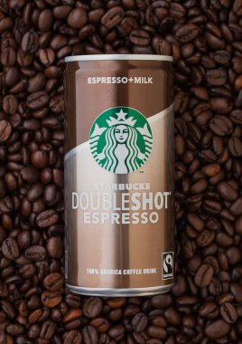 LONDON, İngiltere - 09 Eylül 2020: Taze çiğ kahve çekirdeklerinin üzerine Starbucks çifte espresso konservesi.