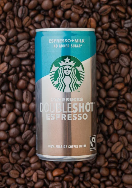 LONDON, İngiltere - 09 Eylül 2020: Taze çiğ kahve çekirdeklerinin üzerine Starbucks çifte espresso konservesi.