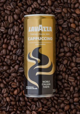 LONDON, İngiltere - SEPTEMBER 09, 2020: Lavazza cappuccino 'nun alüminyum konservesi taze çiğ kahve çekirdeklerinin üzerinde buzlu kahve.