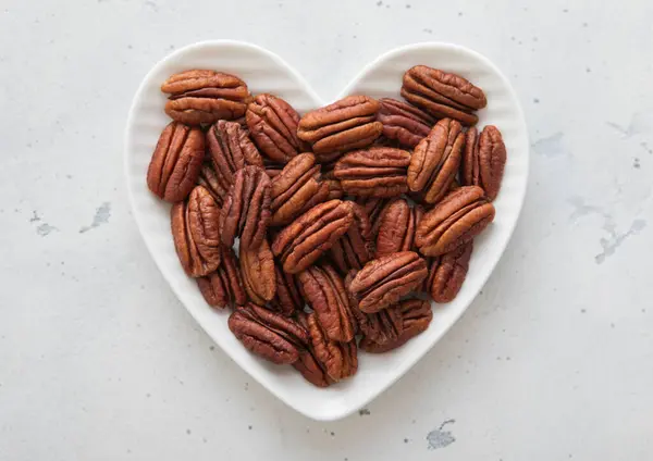 Hartvormige Plaat Met Gezonde Geschilde Pecannoten Lichte Ondergrond — Stockfoto